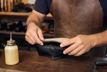 Profissional colando a sola de um tênis para reparo.